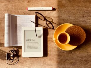 Immagine in evidenza nell'articolo rappresenta un libro cartaceo e la sua versione digitale in formato ebook mostrato attraverso un apposito strumento digitale anche noto come e-reader